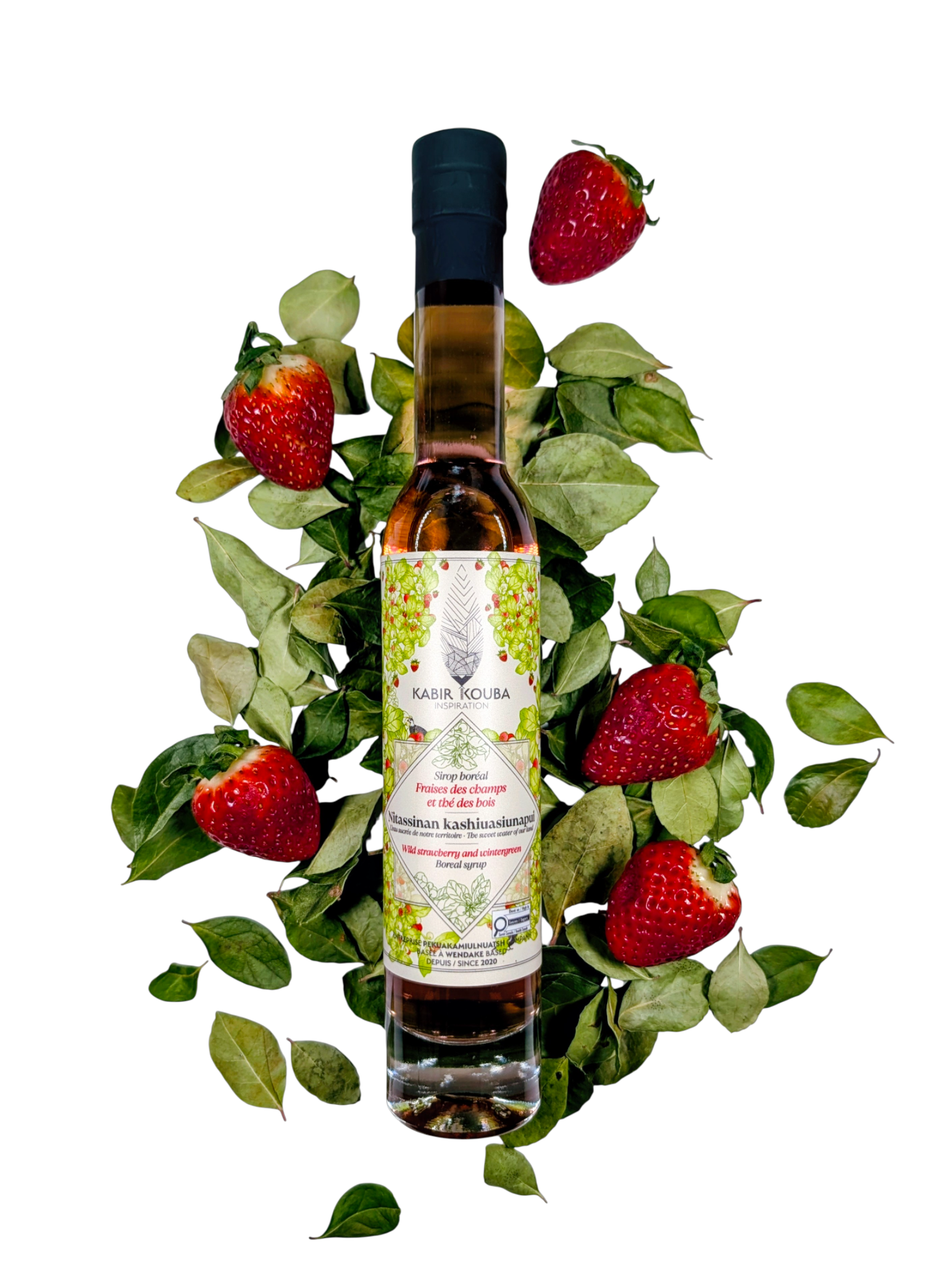 Bouteille de sirop boréal fraise et thé des bois 200 ml par Kabir Kouba Inspiration, entourée de fraises fraîches et de feuilles de thé des bois